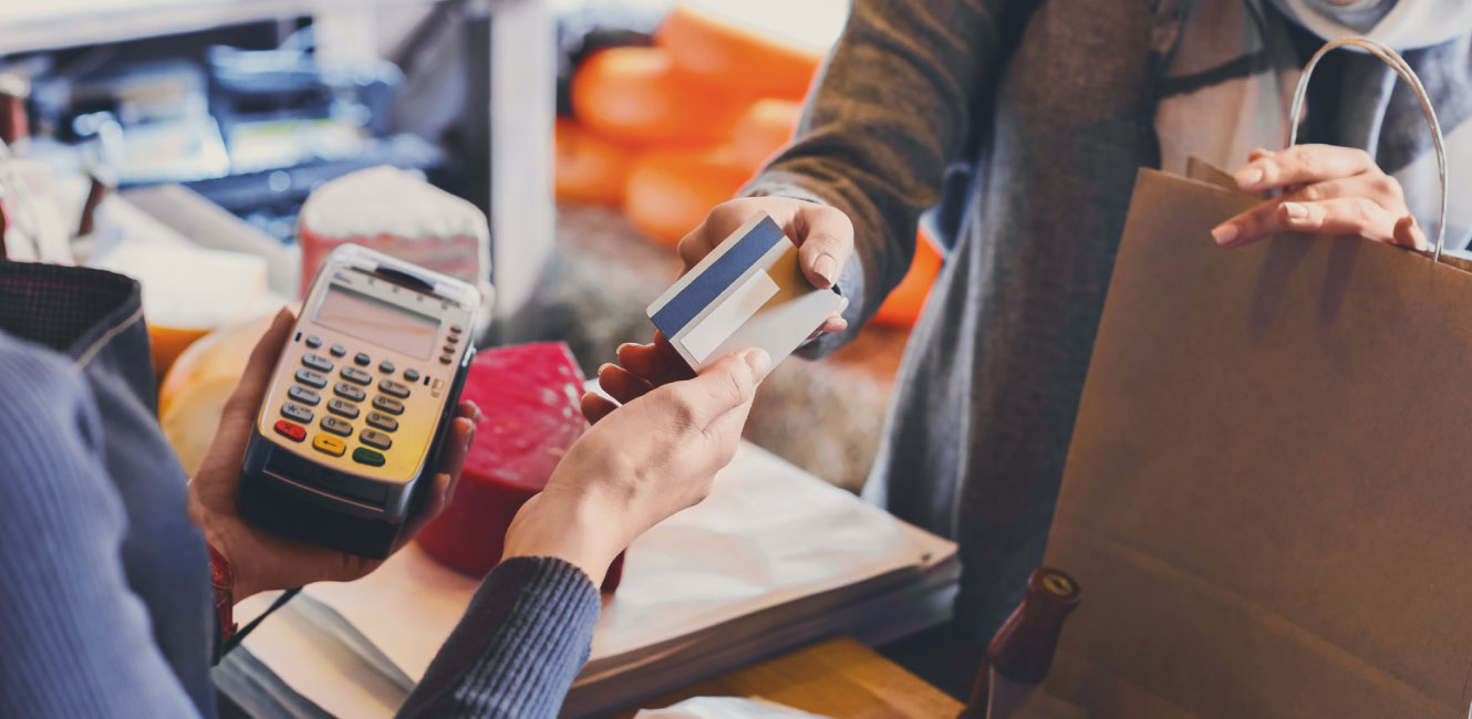 person handing cashier their bank card